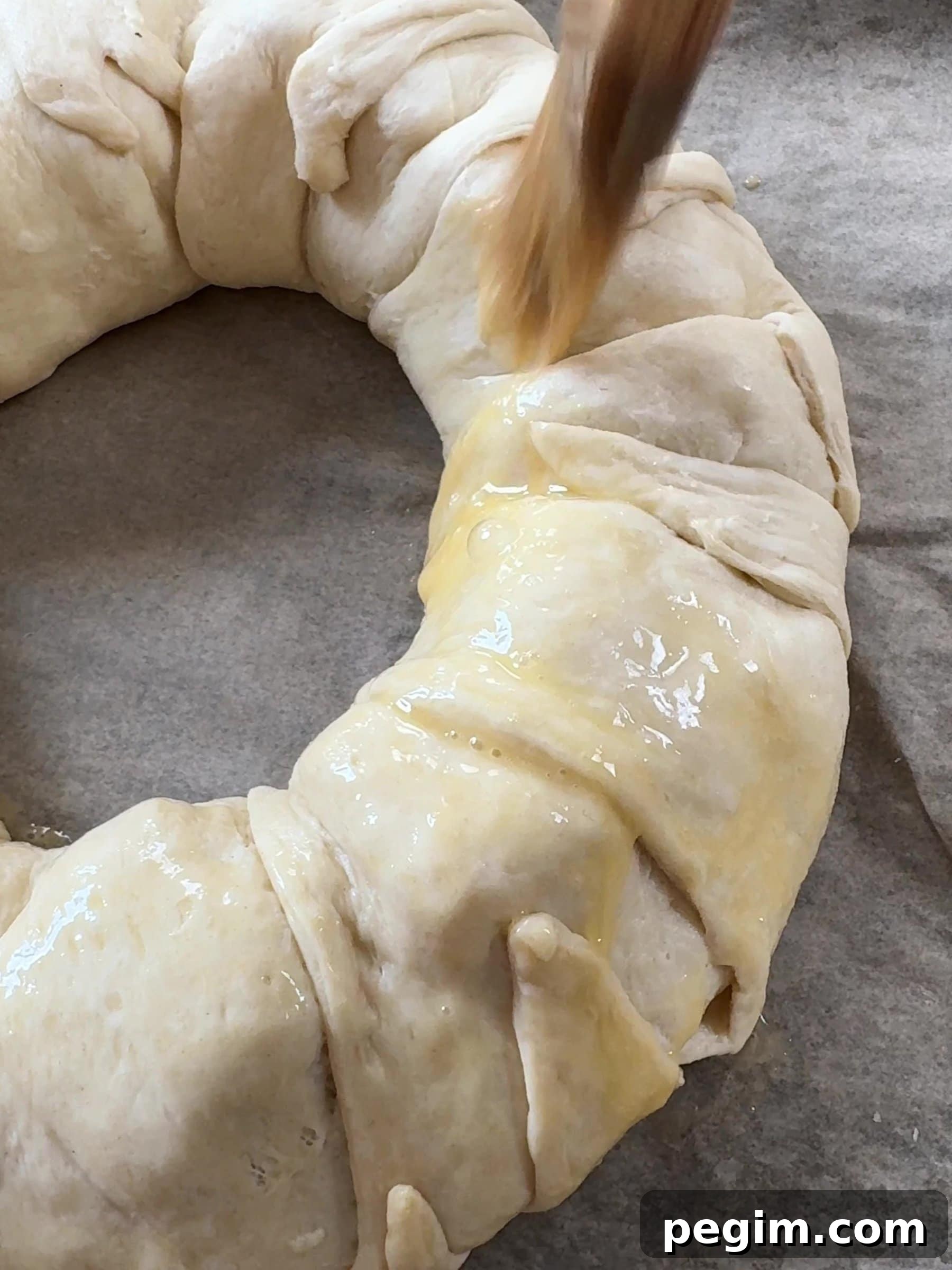 Brushing the Brie Crescent Wreath with egg 