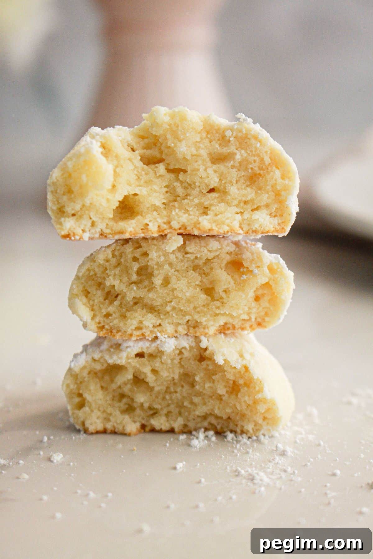 Half almond cream cheese cookies on a counter.