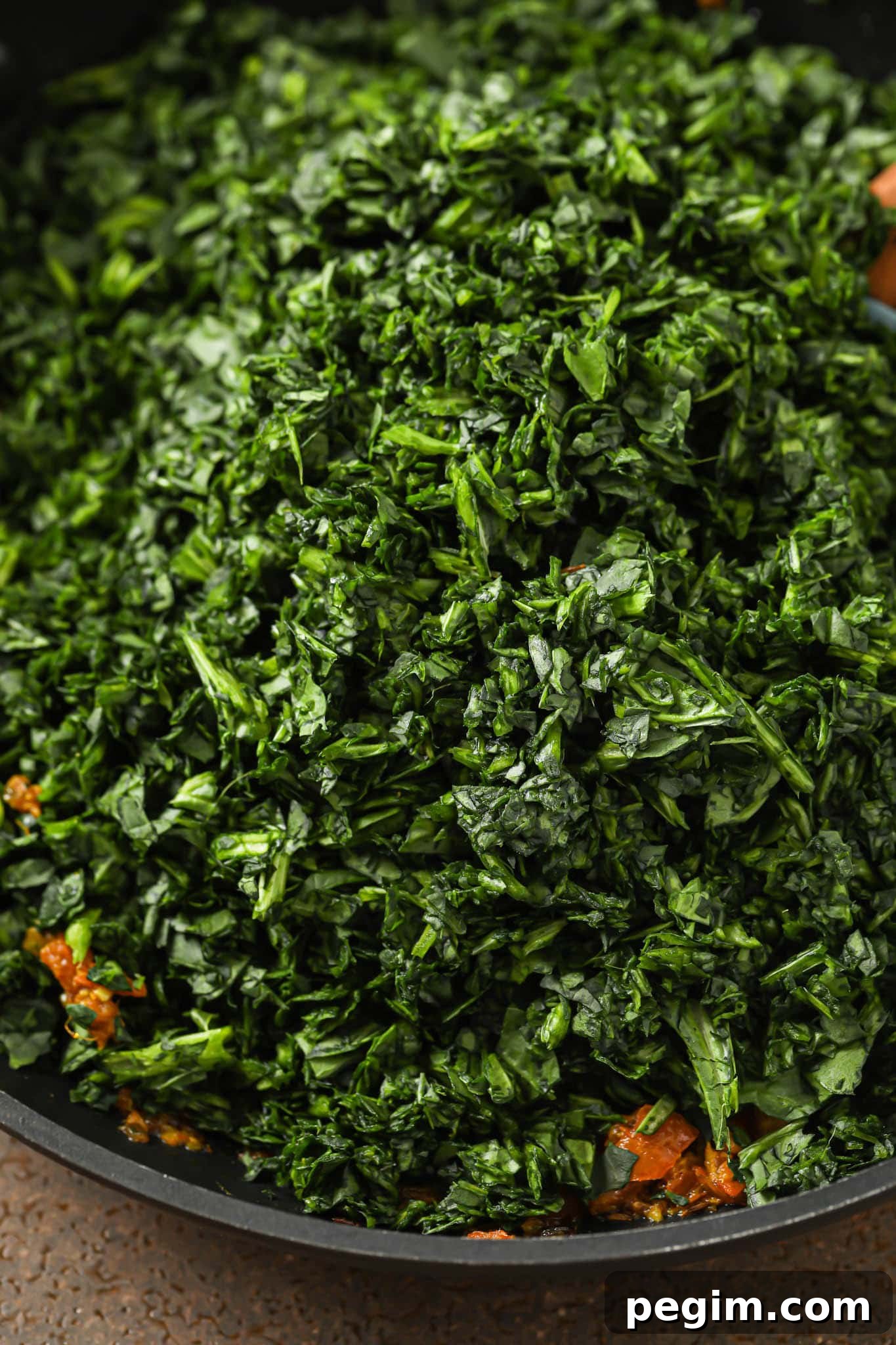 Chopped spinach added to the skillet with onion-tomato mixture.