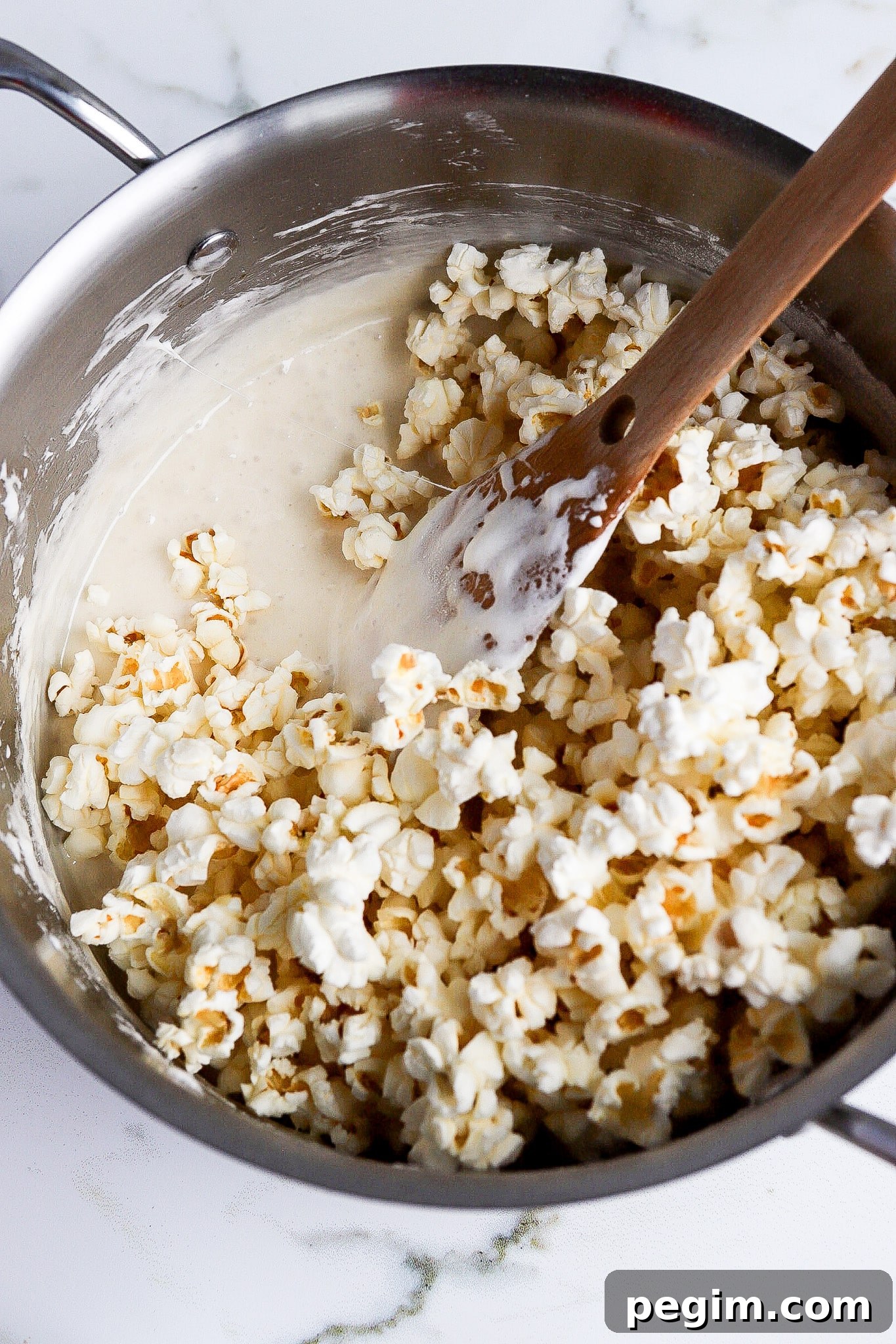 top down view of marshmallows mixed with popcorn in large pot