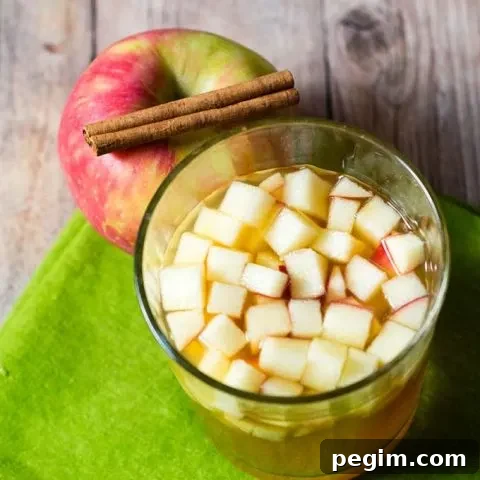 Cinnamon apple cider sangria is a delicious fall cocktail combining white wine, apple cider, apple brandy and cinnamon whiskey. #AppleWeek