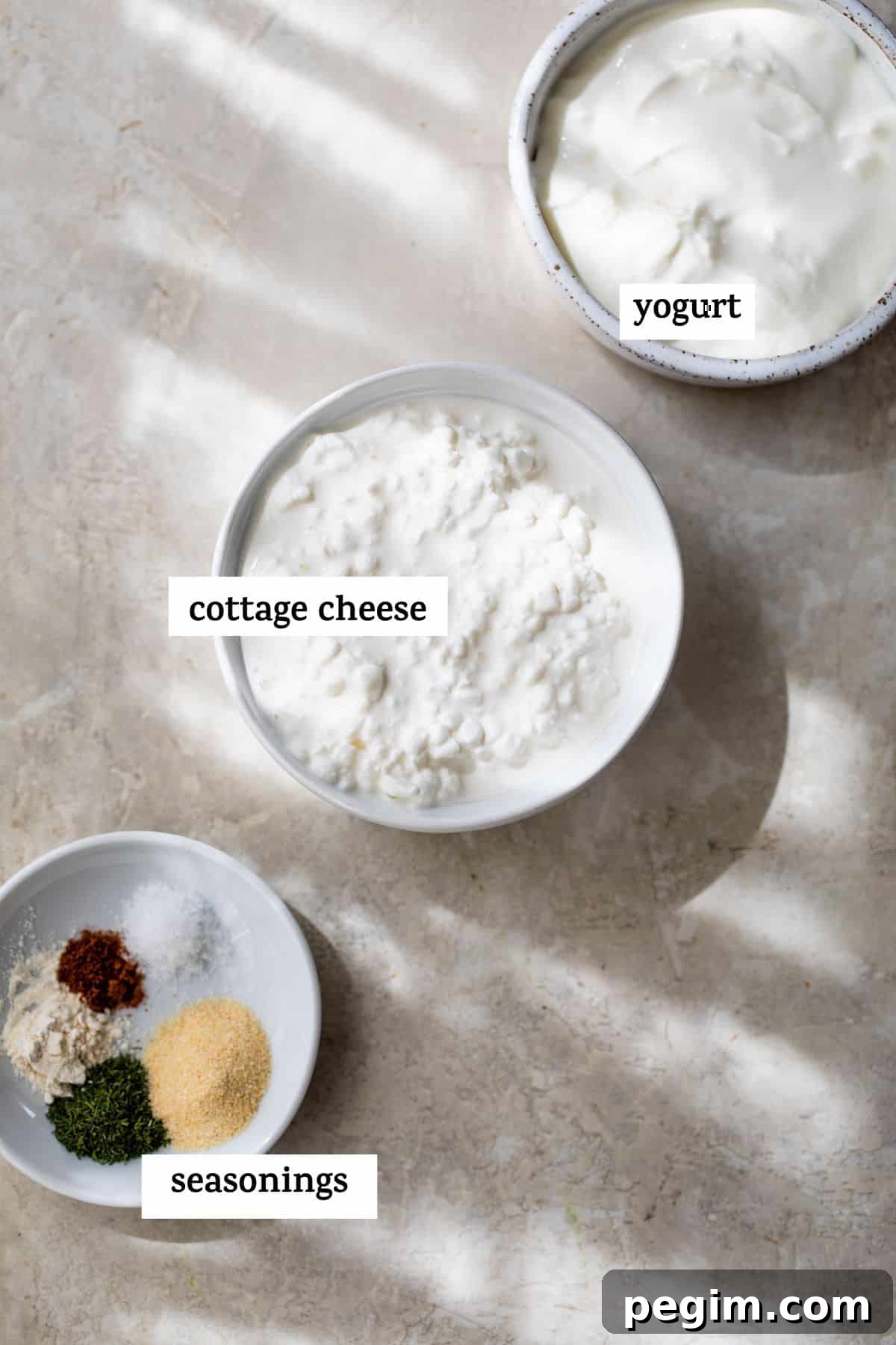 small bowl of yogurt, small bowl of cottage cheese and a small dish with seasonings on it