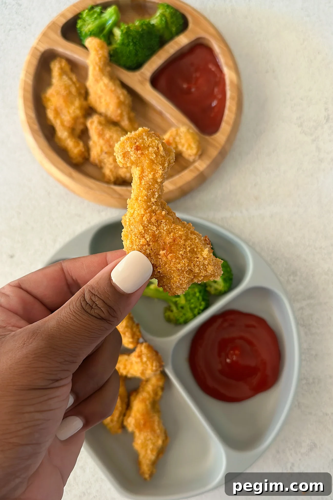 Dino nuggets served with broccoli and ketchup.