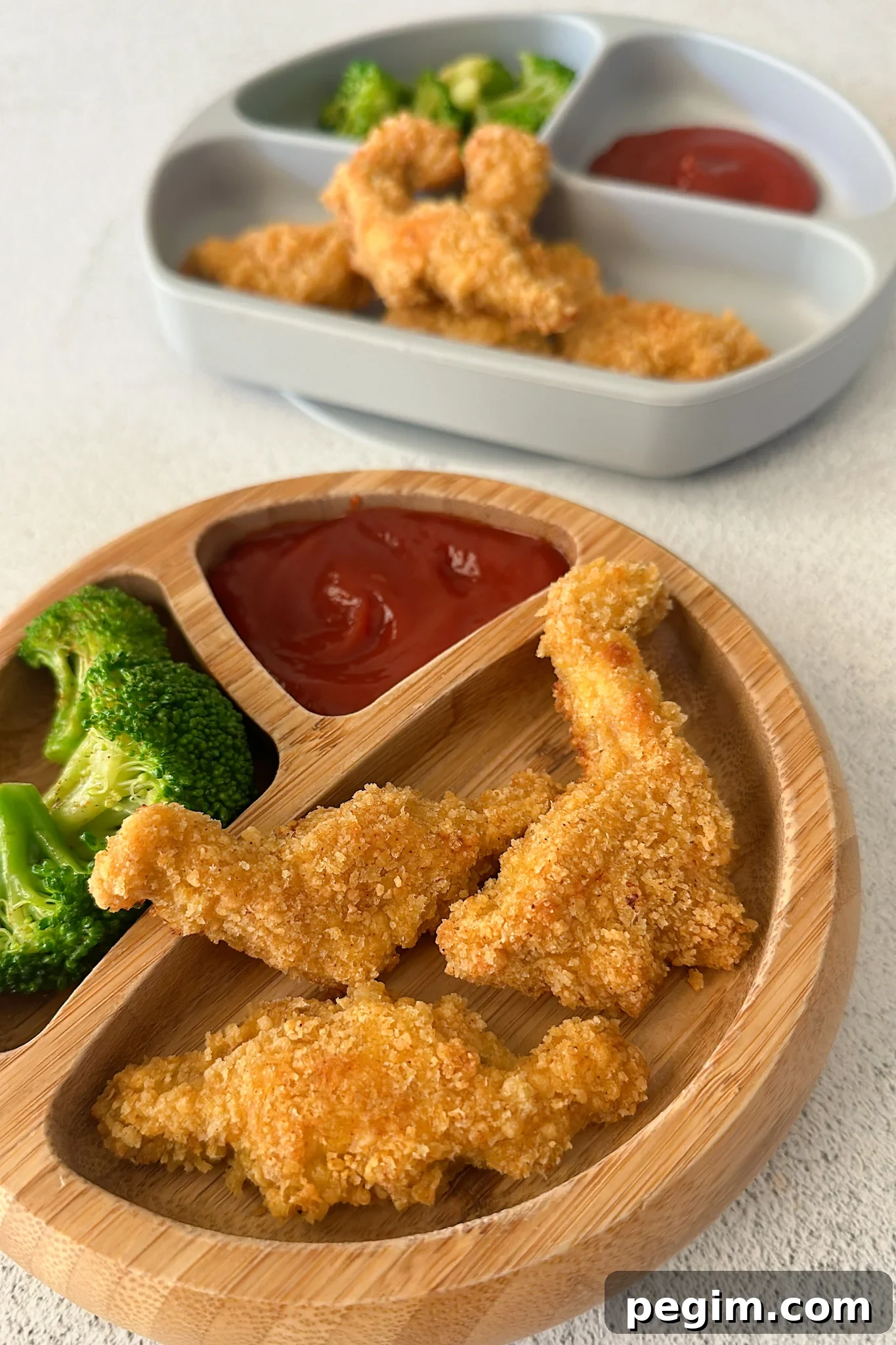 Dino nuggets served with broccoli and ketchup.