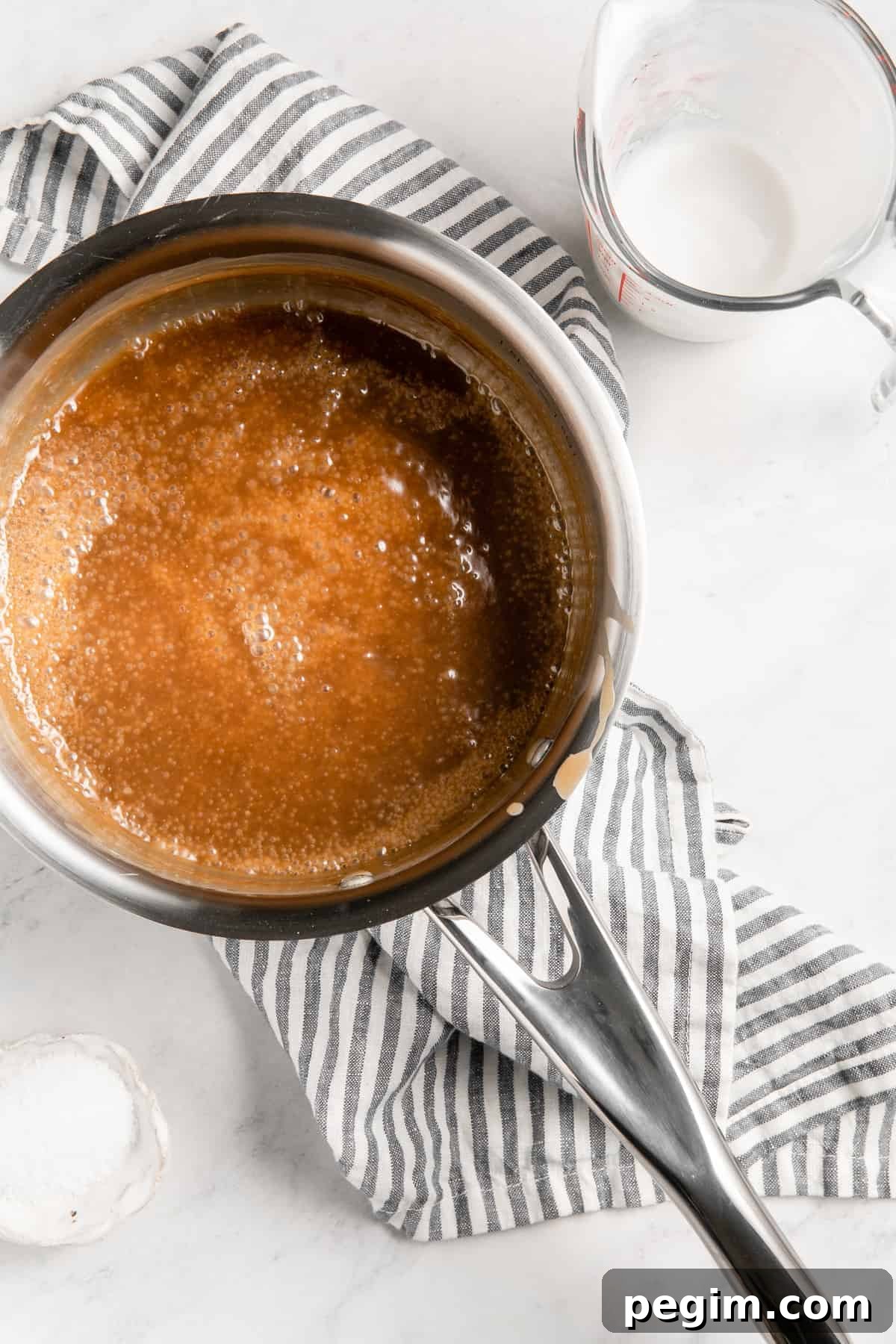 Caramel sauce cooking in a saucepan.