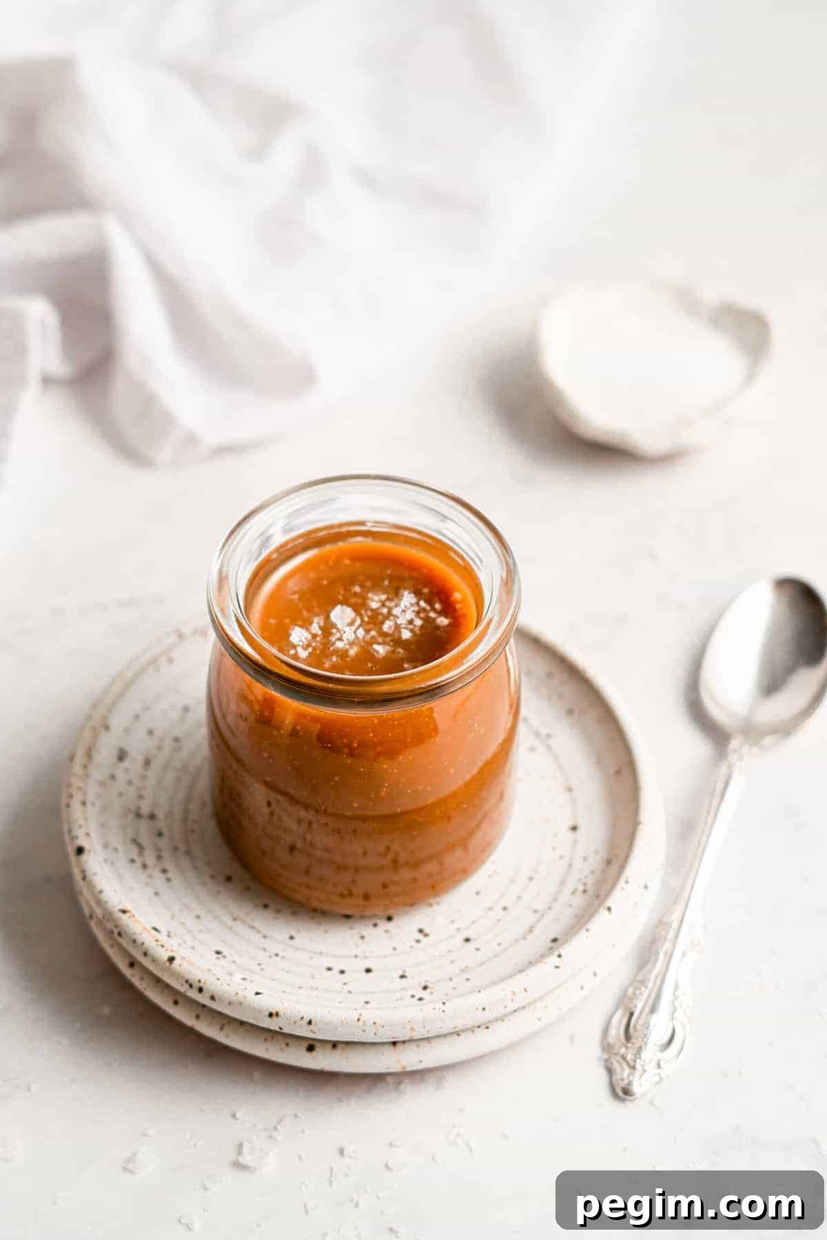 A jar of vegan caramel sauce on a plate.