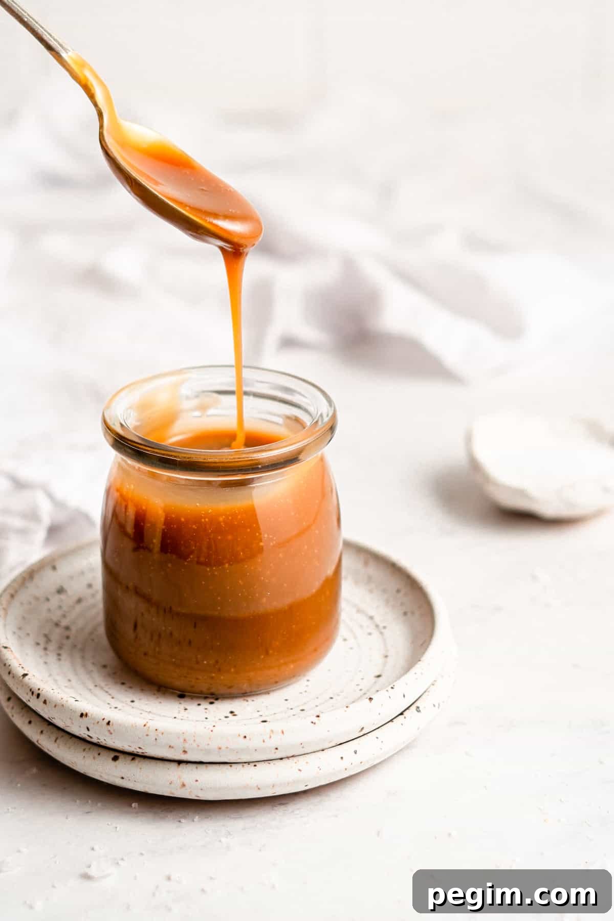 Homemade caramel sauce in a glass jar.