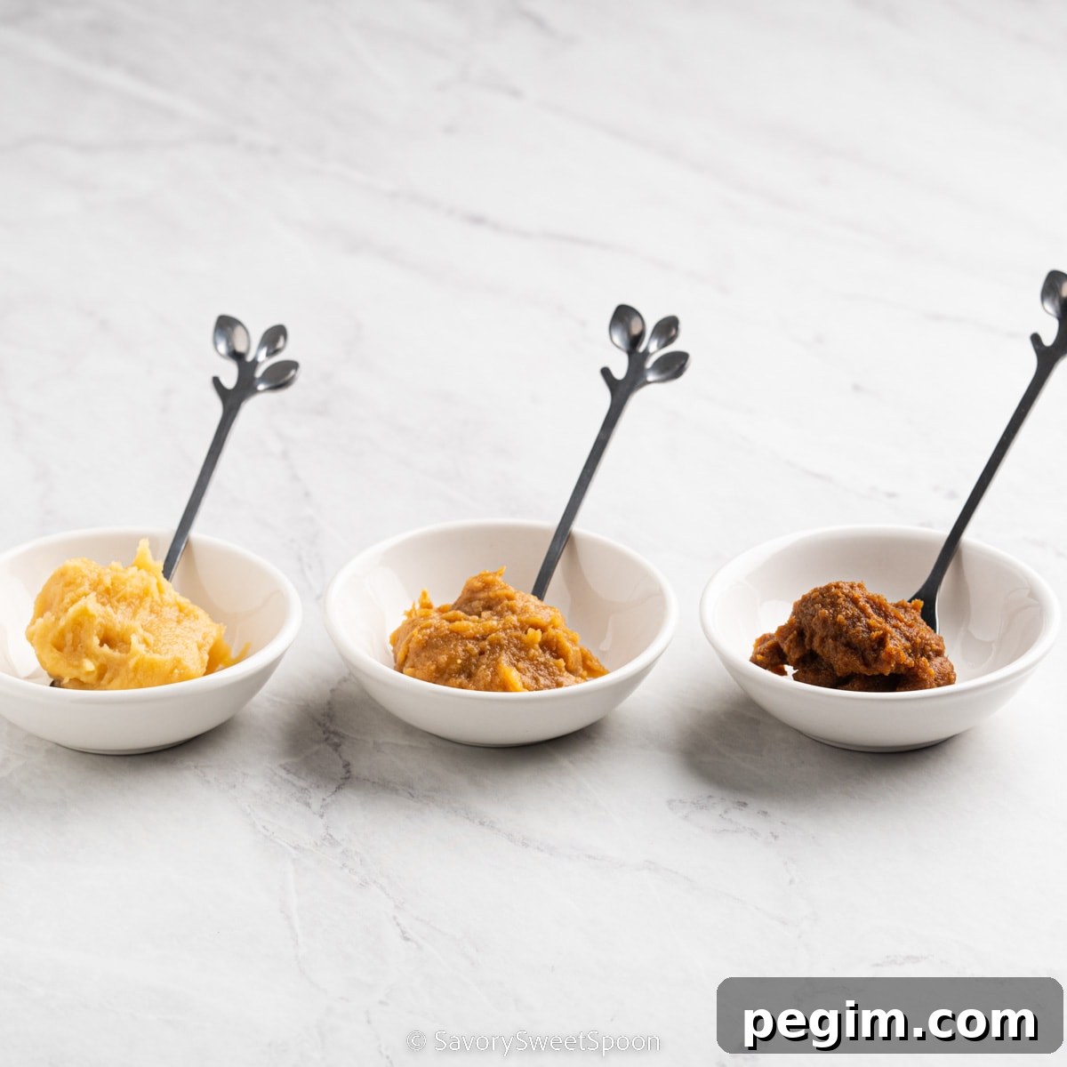 three different kinds of miso paste in small dishes.