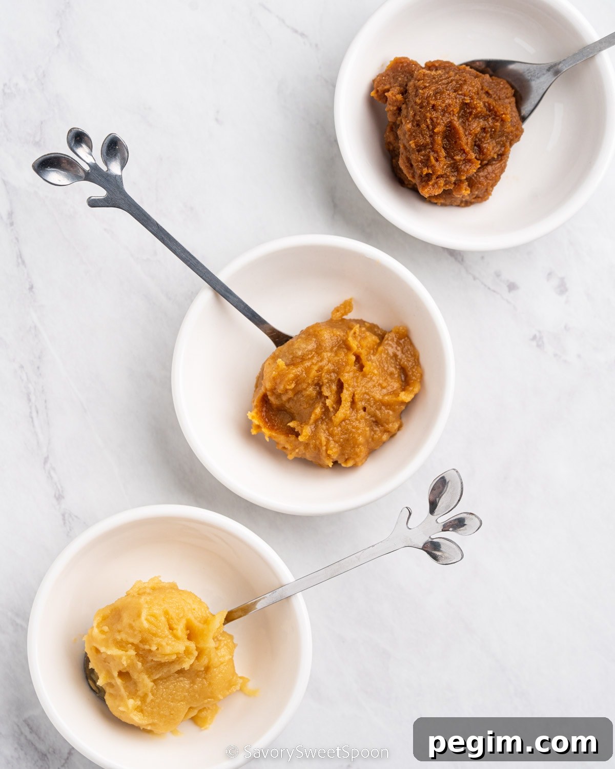 three different kinds of miso paste in small dishes.