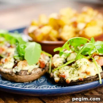 Panchetta mushrooms with mozzarella on a blue plate served with potato squares