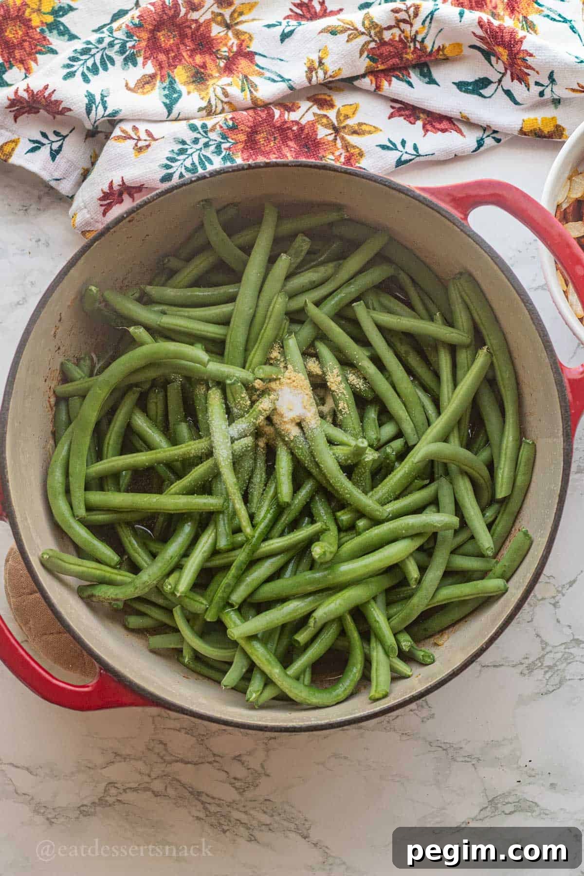 Raw green beans with spices and broth in pan.