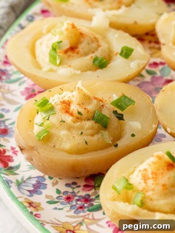 Filled deviled potatoes on floral plate.