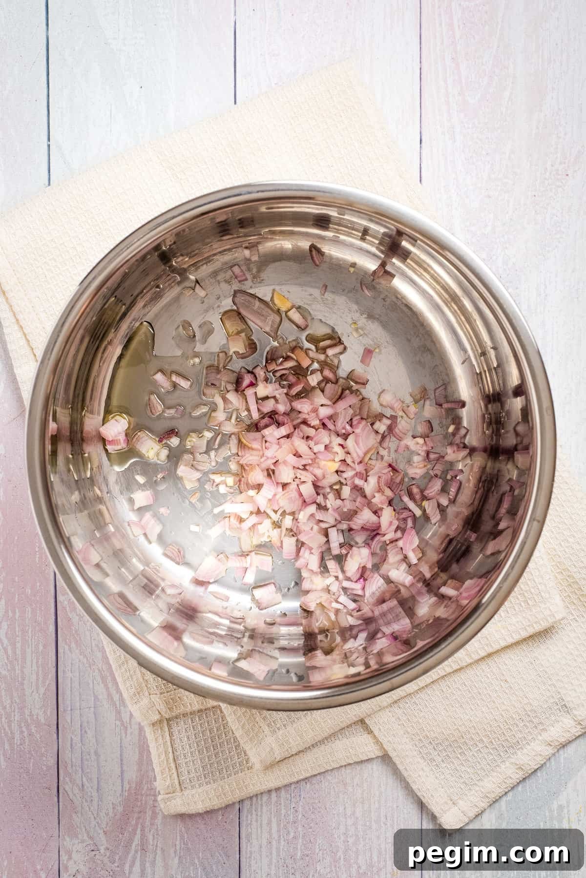 Overhead view of chopped shallots and garlic sauteed in a pot.