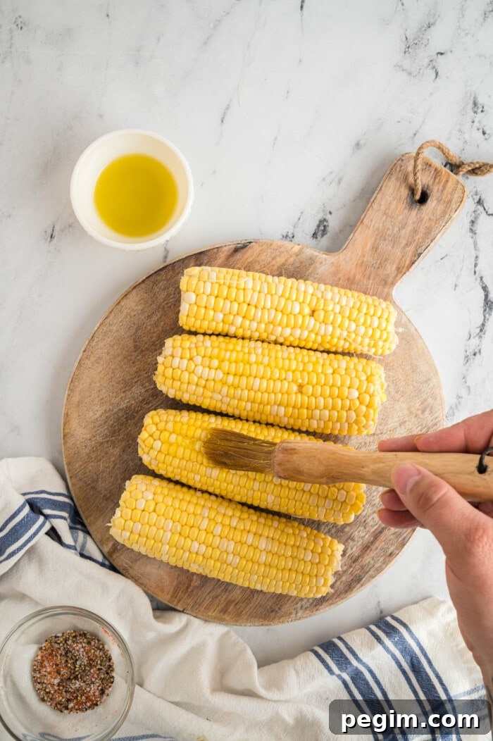 Crispy Air Fryer Corn on the Cob Recipe 4 brushing corn on the cob with butter
