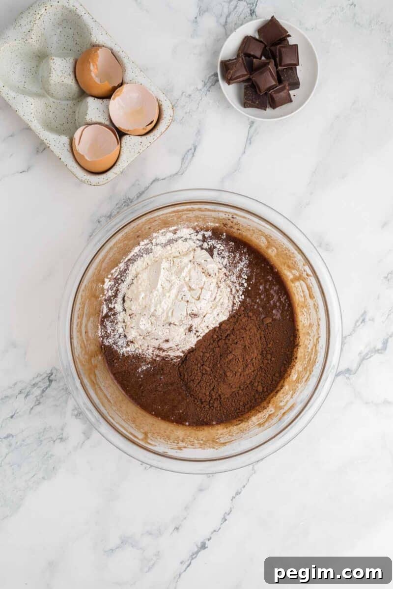 A bowl of brown powder and a bowl of eggs.