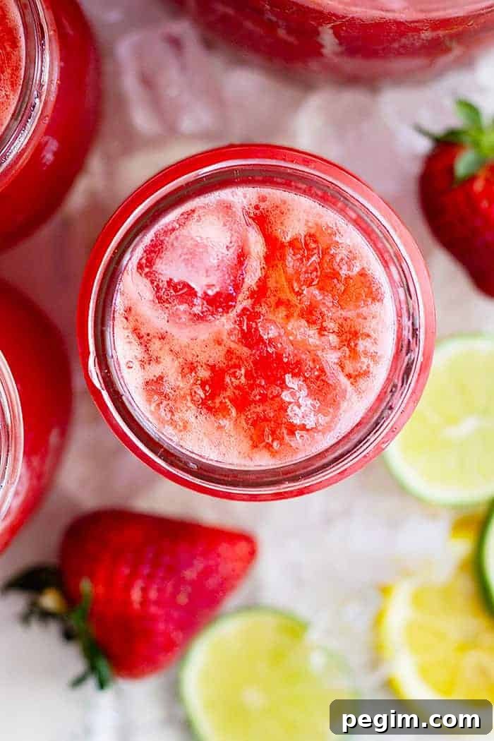 overhead closeup: a glass of strawberry lemonade margarita with coarse salt on top