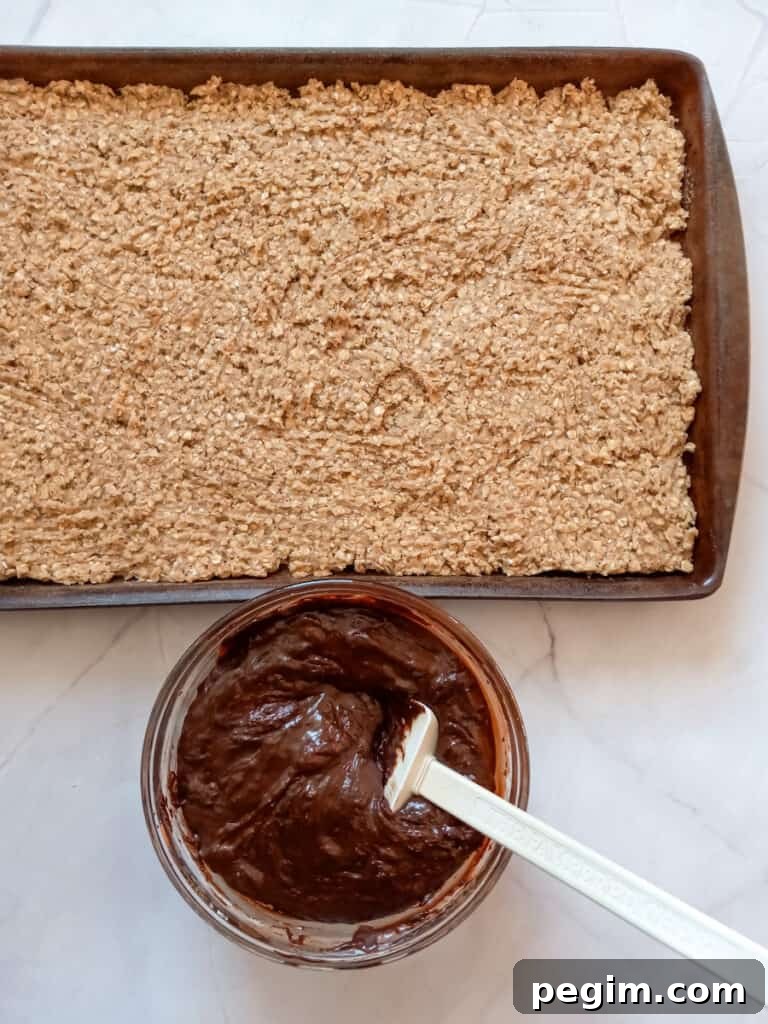 part of the oat mixture spread into a 10x15" pan with the chocolate fudge in a separate bowl.