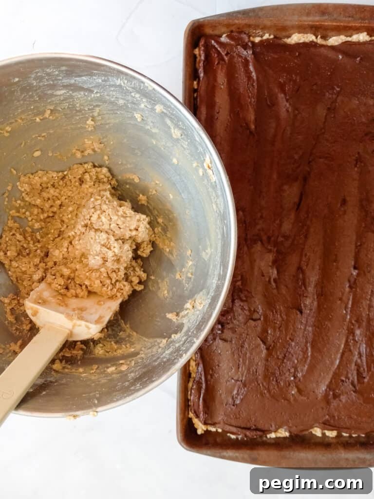 ready to spread the remaining oat mixture over the fudge layer.