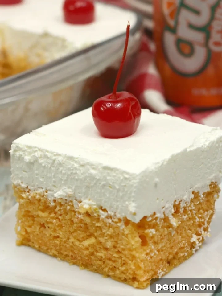 Slice of orange crush cake topped with a cherry