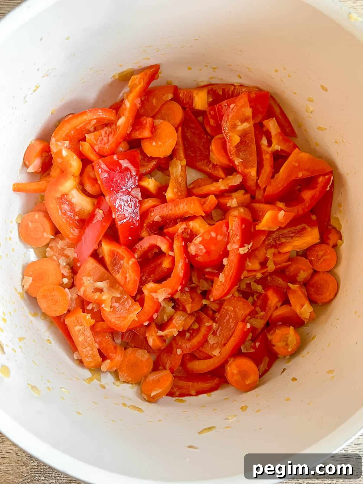 Bell peppers and carrots in a pan.
