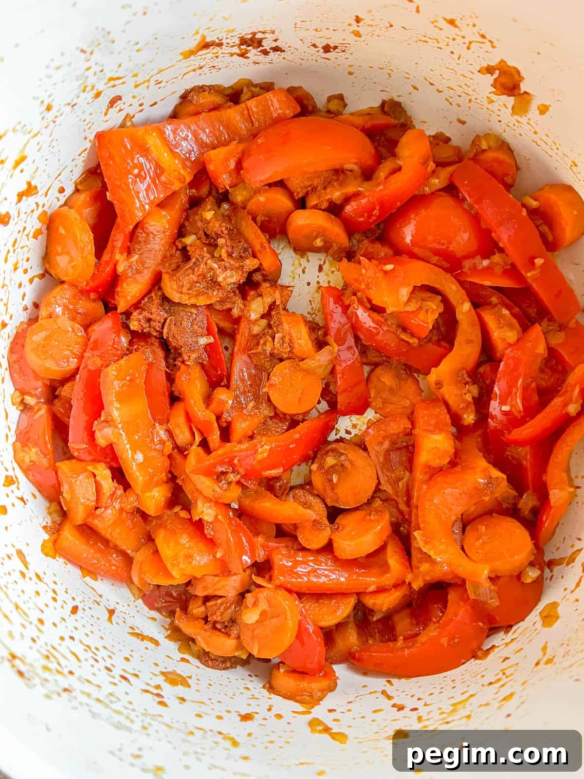 Red curry paste added to the pan.