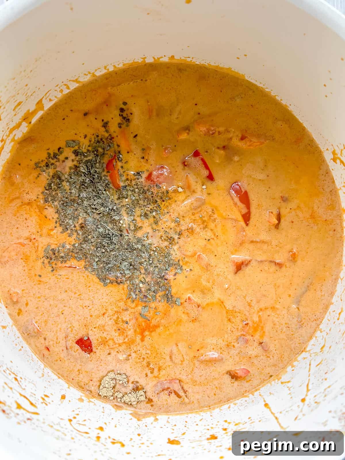 Dried basil and spices added to paleo Thai red curry.