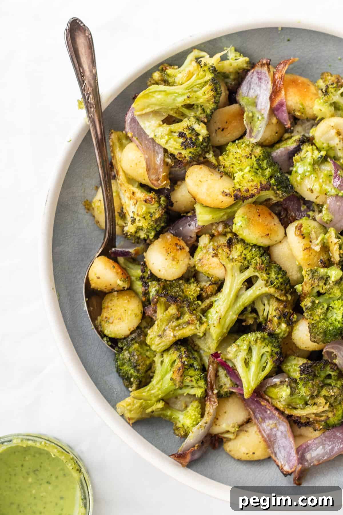 sheet pan gnocchi in a bowl with a spoon.