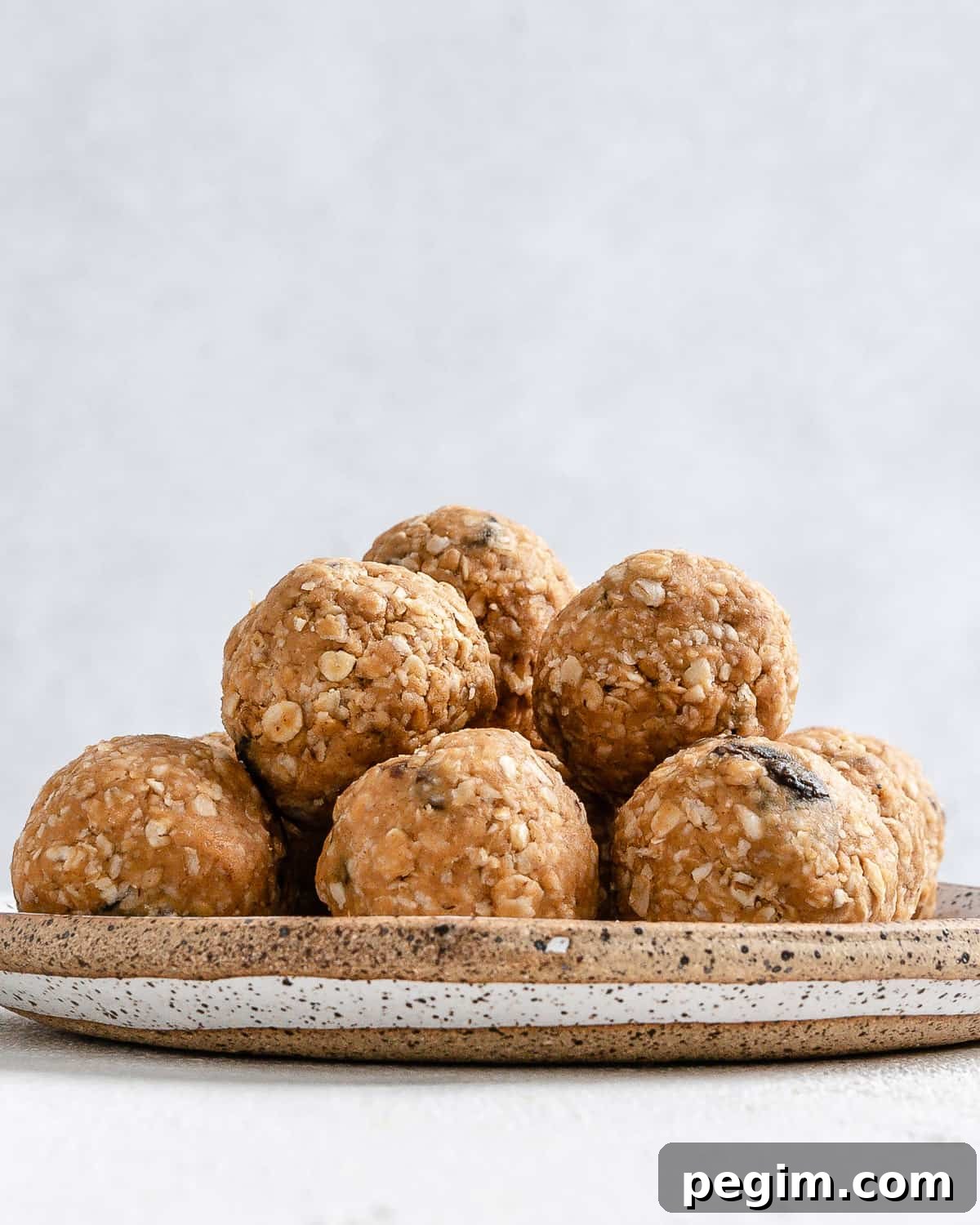 completed Oatmeal Raisin Protein Balls on a plate against a white background