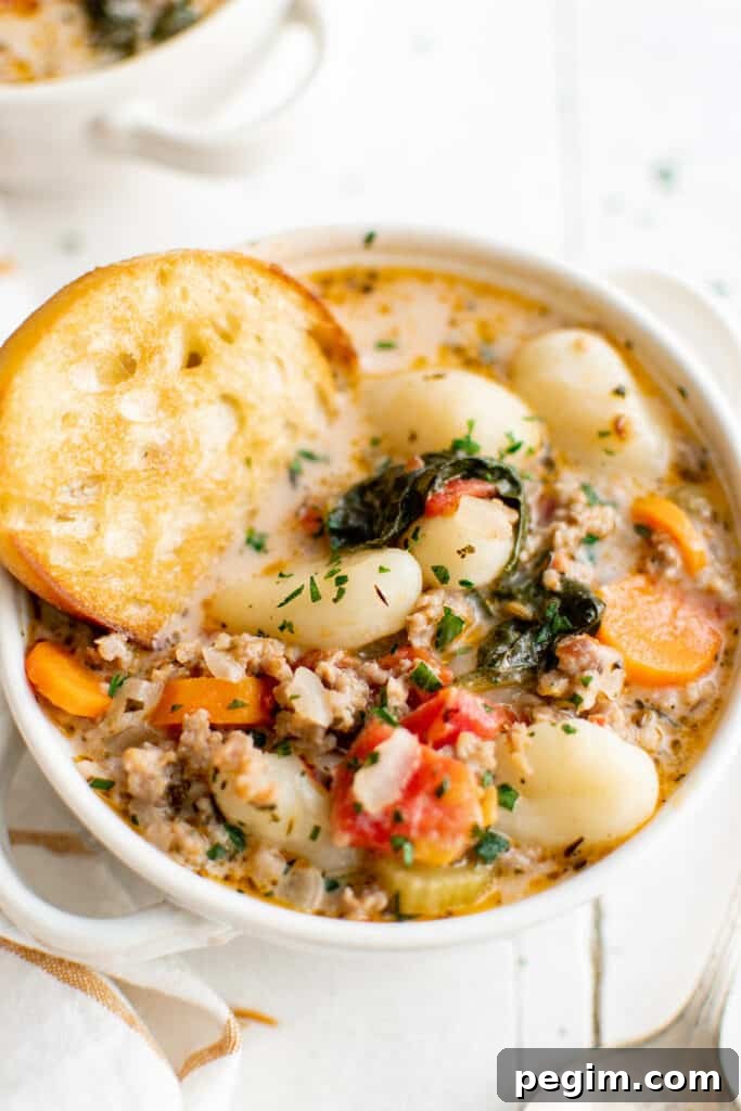 sausage gnocchi soup with bread in a bowl