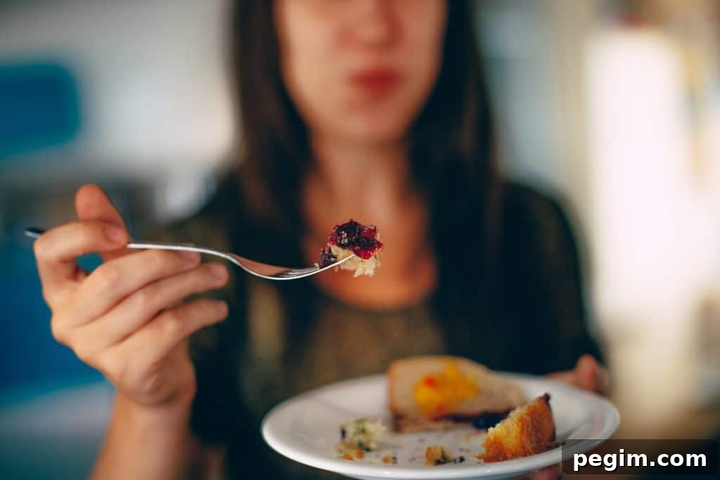 Woman holding a bite of cake with jam to the camera