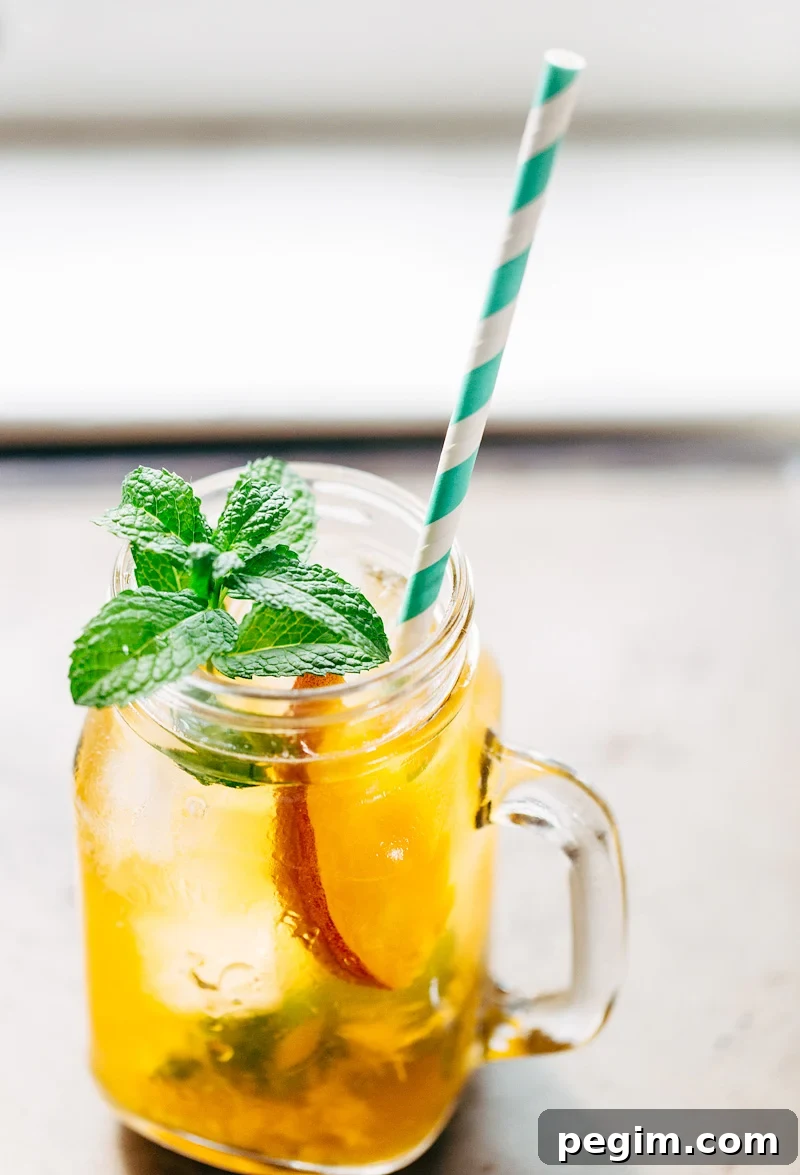 Peach iced tea with a green and white straw