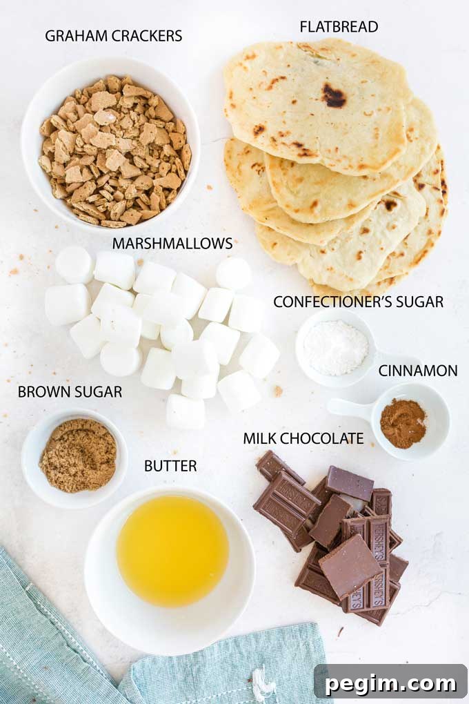 Ingredients to make s'mores flatbread on a white surface.