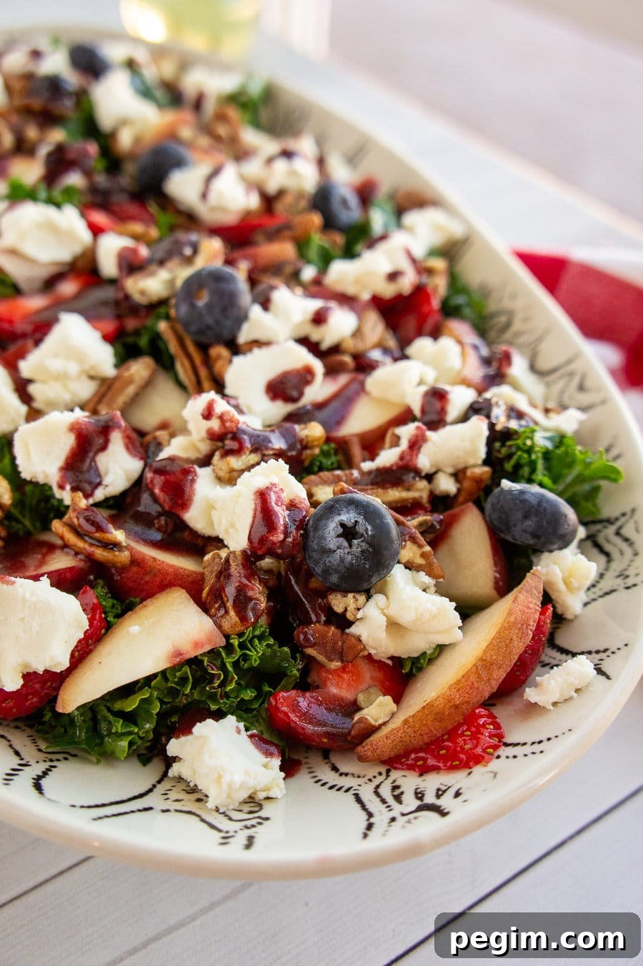 kale salad with berries, peaches, and cheese.