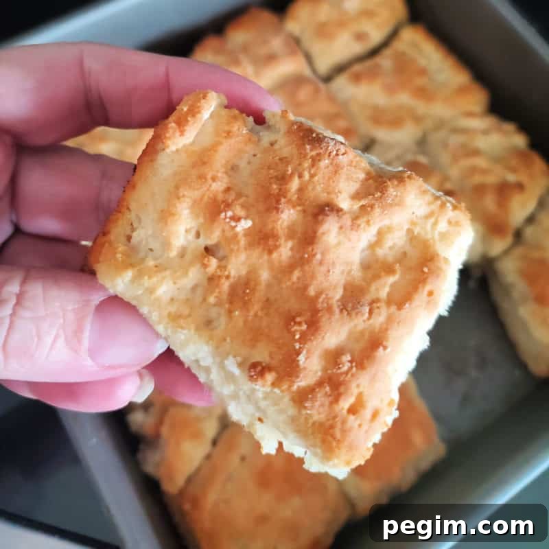 7 Up biscuit being held above a pan of biscuits