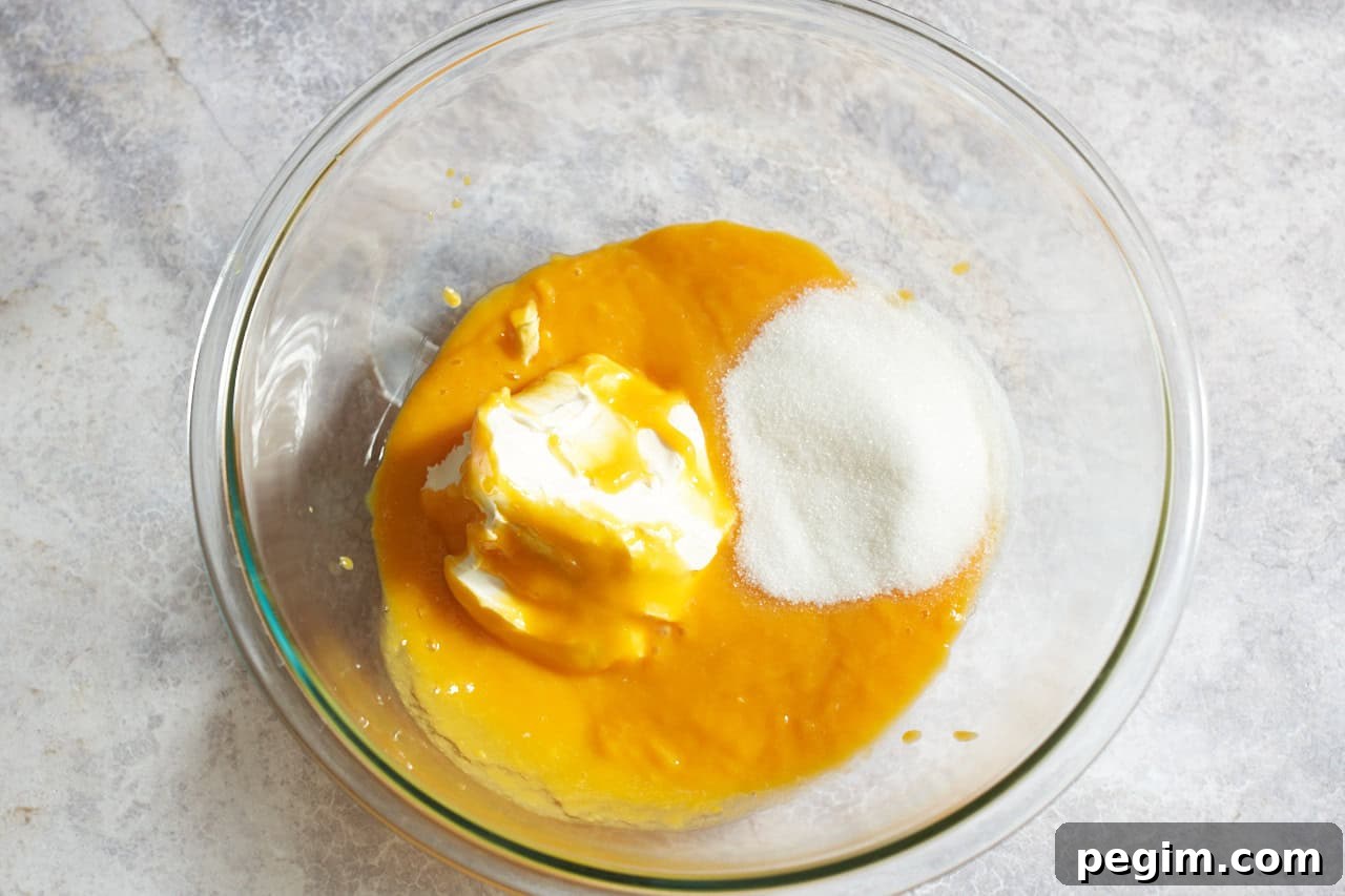 A bowl with fresh mango pulp, sugar, and mascarpone cheese.