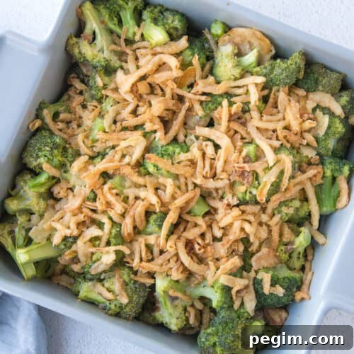 broccoli casserole with fried onions in a gray square casserole dish.