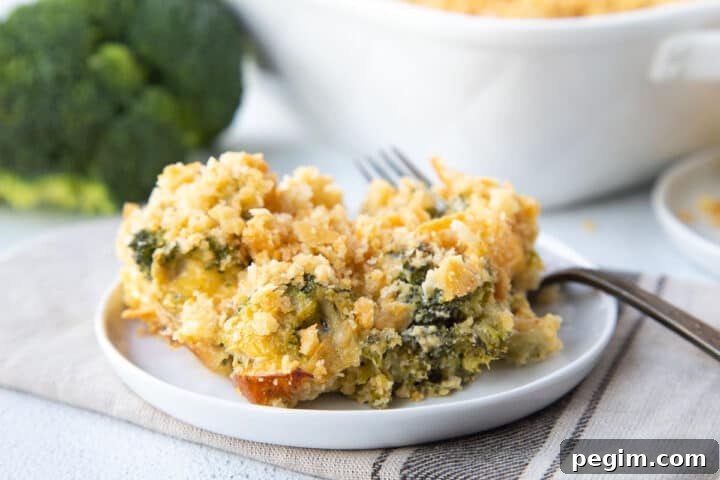 broccoli casserole on a white plate with a fork.
