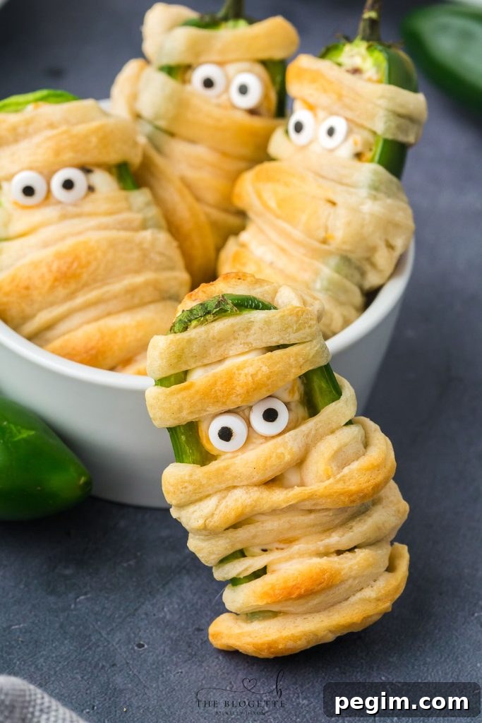 Halloween Jalapeño Popper Mummies are adorably spooky jalapeños, filled with a cream cheese mixture, wrapped in crescent dough, and baked!