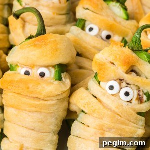 Halloween Jalapeño Popper Mummies are adorably spooky jalapeños, filled with a cream cheese mixture, wrapped in crescent dough, and baked!