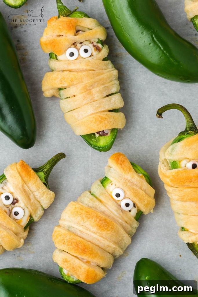Halloween Jalapeño Popper Mummies are adorably spooky jalapeños, filled with a cream cheese mixture, wrapped in crescent dough, and baked!