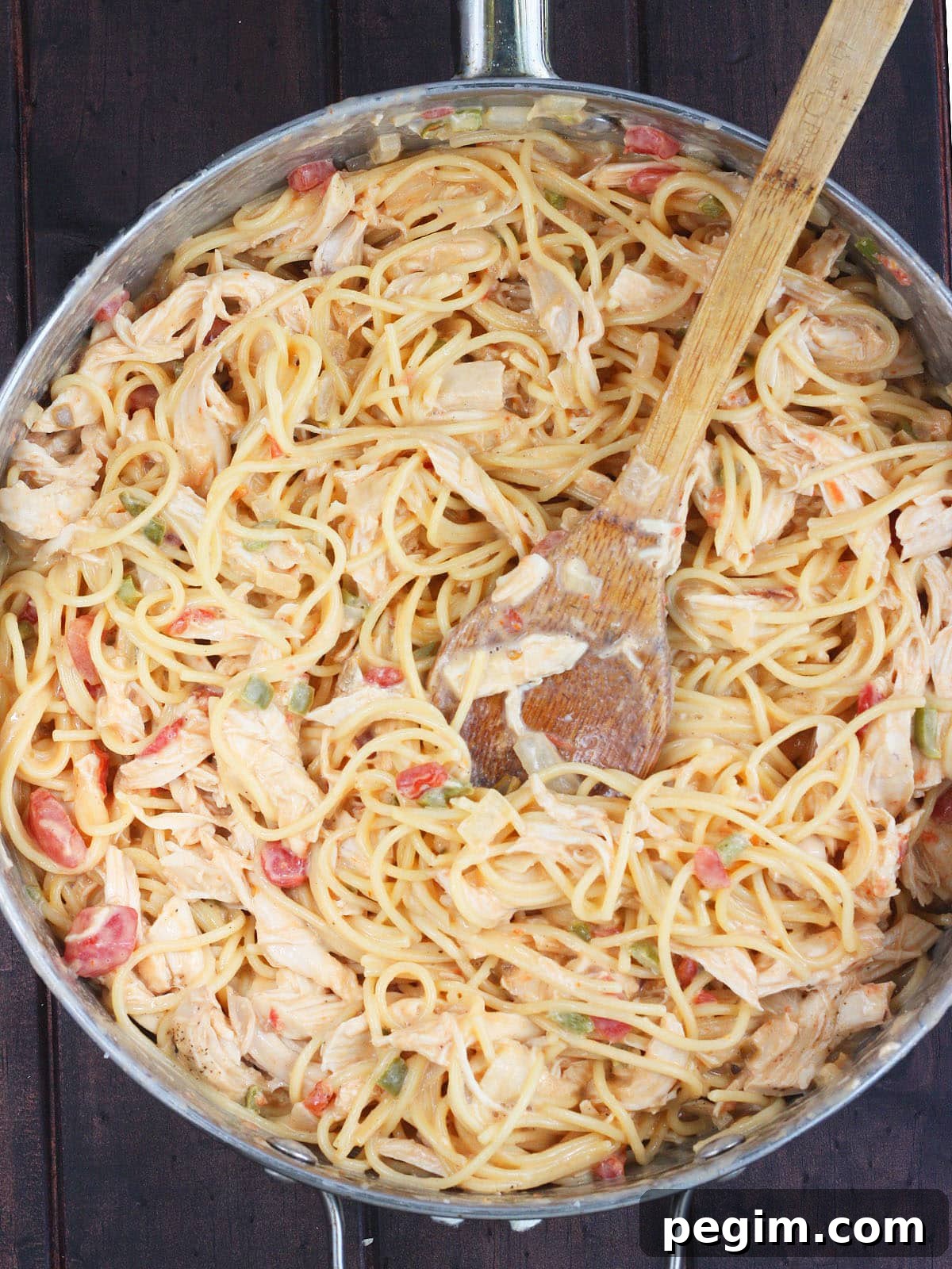spaghetti noodles mixed with cheese, vegetables and rotel tomatoes in a large skillet