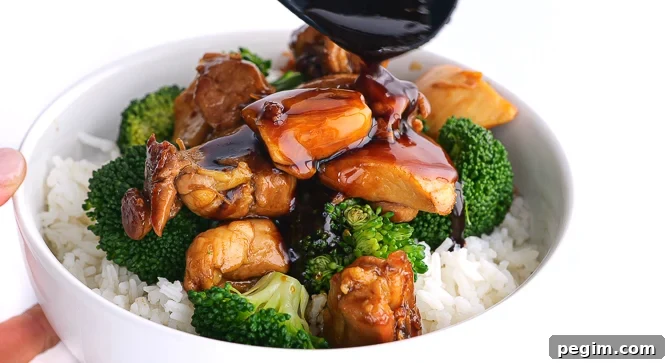 pouring sauce on top of chicken, broccoli and rice in white bowl