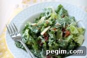 A serving of Sarah's Salad in a bowl with a fork sitting on the rim on the left. The bowl is sitting on a cloth yellow and white dotted napkin.