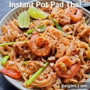Instant Pot Pad Thai with chicken & shrimp being lifted with a tong