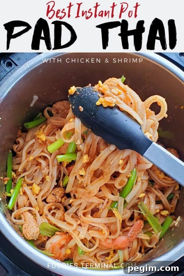 instant pot chicken shrimp pad thai being lifted with tong from the pressure cooker