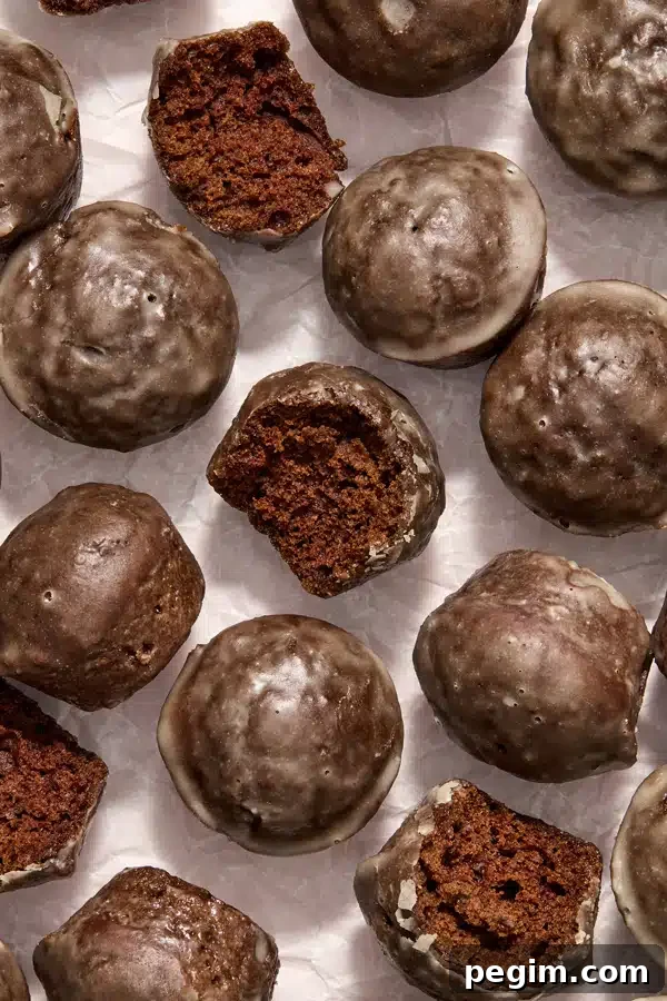 Gluten Free Dairy Free Donut Holes on parchment with a bite taken from a few.
