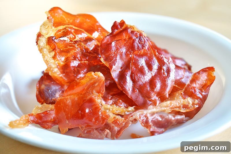 A white plate filled with Porkitos (Crispy Prosciutto Chips) 