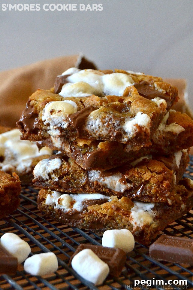 small stack of s'mores cookie bars on wire rack with mini marshmallows and chocolate