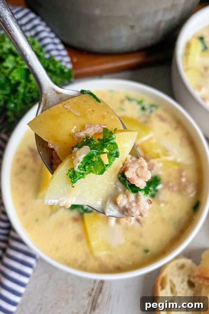 close up photo of zuppa Toscano soup on a serving spoon topped with fresh chopped parsley.