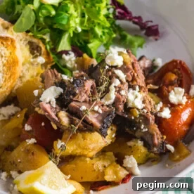 Slow roasted Greek lamb in a white dish with feta and lettuce